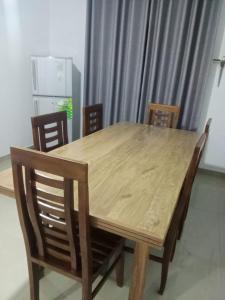 a wooden dining table with chairs and a refrigerator at Nadi Villa Midigama in Midigama East