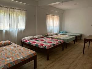 a room with three beds in a room at Jarens Diner in Silang
