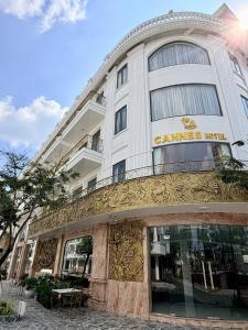 a building with a sign on the side of it at Cannes Ben Tre Hotel in Ben Tre