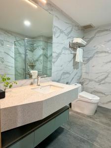 a bathroom with a sink and a toilet and a mirror at Cannes Ben Tre Hotel in Ben Tre +58 photos