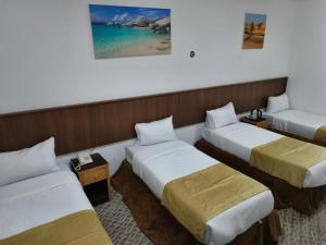 a hotel room with three beds and the ocean at فندق الواحة الماسية نجمة 1 in Mecca
