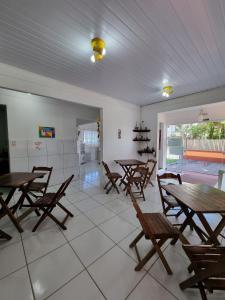 a dining room with wooden tables and chairs at Recanto Aconchego Itapoá in Itapoa