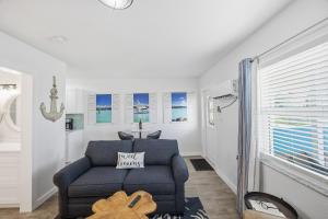 a living room with a blue couch and a window at 107 · Boat dock- BBQ Walk to Beach GREAT VIEWS in St. Pete Beach