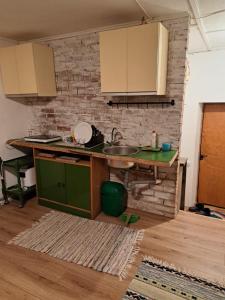 a kitchen with a sink and a brick wall at Augšistaba Beči in Vecumnieki
