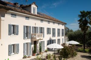 a white building with two umbrellas in front of it at Tenuta Dei Vicini - Luxury Apartments in San Marzano Oliveto
