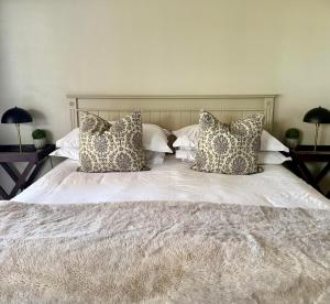 a bedroom with a bed with pillows on it at De Gunst Guest Farm in Malmesbury