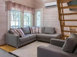 a living room with a couch and some windows at Holiday Home Sini 2b by Interhome in Lahdenperä