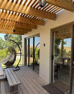 a wooden deck with a bench and a swing at De Gunst Guest Farm in Malmesbury