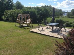 a picnic table and a playground in a field at Holiday Home Jokela by Interhome in Horonkylä
