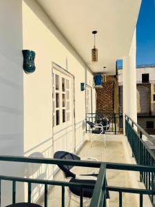 a balcony with chairs and a table on a building at Happiness Guest House in Luxor