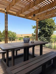 a wooden table and benches on a deck at De Gunst Guest Farm in Malmesbury