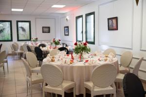 a dining room with tables and chairs with roses on them at Domaine de Pousiniès in Saint-Étienne-de-Tulmont