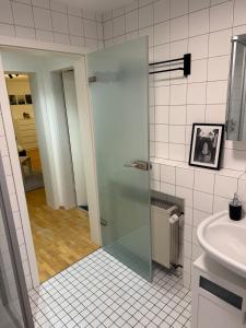 a bathroom with a glass shower door next to a sink at Ferienwohnung Engels in Olpe