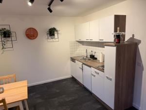 a kitchen with white cabinets and a sink at Ferienwohnung Engels in Olpe +11 photos