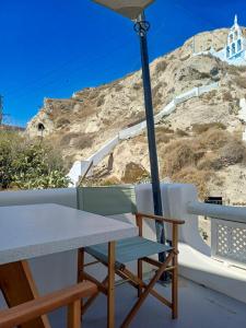 a table and chair with an umbrella on a balcony at Ecolodge Cave House in Vóthon