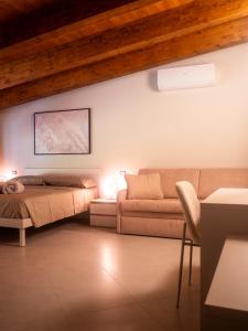 ein Wohnzimmer mit einem Bett und einer Couch in der Unterkunft Agriturismo Risaltro in Trino
