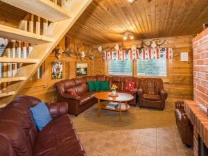 a living room with leather furniture and a table at Holiday Home Metsämökki by Interhome in Barkarböle