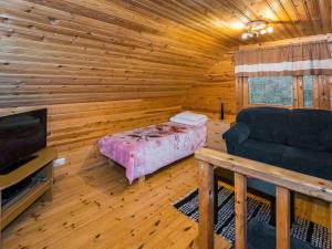 a room with a bed and a couch in a log cabin at Holiday Home Metsämökki by Interhome in Barkarböle +12 photos