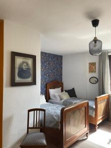 a bedroom with two beds and a chair at Gastwerk Waldfrieden in Gießen