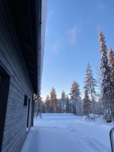 a snow covered field with trees and a building at Villa Luokka, Iso-Syöte in Syöte