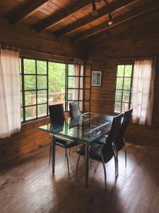 a dining room with a glass table and chairs at Casa Chichipio in Tigre