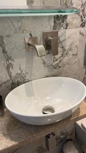 a white sink in a bathroom with a marble wall at Angelos House Deluxe Apartments in Skiathos +38 photos