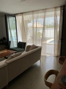 a living room with a couch and a large window at Lulu Diani in Diani Beach