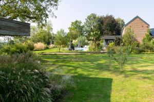 a garden with a bench in the middle of a yard at les jardins de la ferme in Soumagne