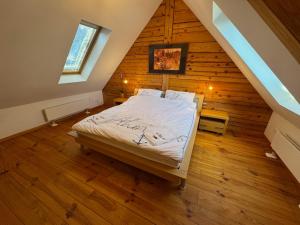 a bedroom with a bed in a wooden house at Frida Farm Vendégház in Kétvölgy