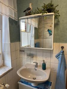 a bathroom with a sink and a mirror at Ferienwohnung Schröder in Putbus
