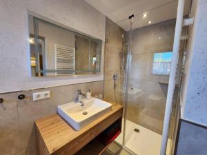 a bathroom with a sink and a shower at Gästehaus Hölzl in Itter +19 photos