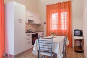 a kitchen with a table with chairs and a television at La Camelia in Riposto