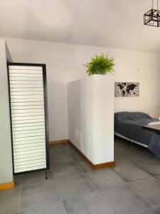 a bedroom with a bed and a plant on the wall at AlojaMenta in Nono