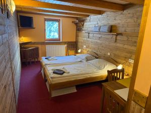 a bedroom with a bed in a wooden wall at Penzion Kapitanka in Kořenov