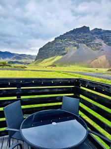 a table and chairs with a view of mountains at Aurora Cabin and Private Jacuzzi in Hvolsvöllur +33 photos