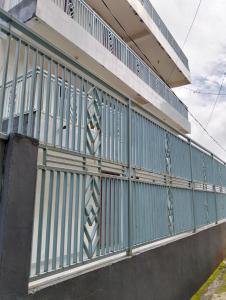 a building with a green and white fence at Penginapan amalia in Soreang