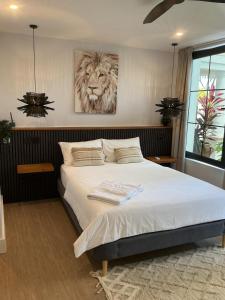 a bedroom with a bed with a lion painting on the wall at Lulu Diani in Diani Beach +32 photos