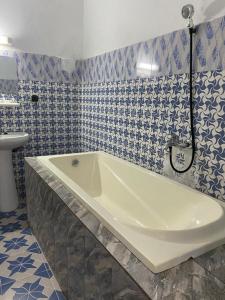 a bath tub in a bathroom with blue and white tiles at Lege Bonoua in Bonoua +16 photos