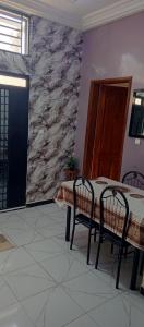 a dining room table with two chairs and a stone wall at Residence Maachaalah in Saint-Louis