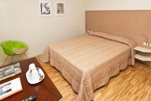 a small bedroom with a bed and a table at Stile Libero in Orio al Serio