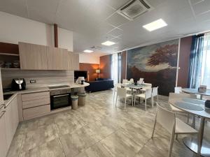 a large kitchen and dining room with tables and chairs at Volpedo hostel in Volpedo
