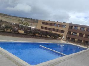 a large blue swimming pool in front of a building at El Refugio in Fuenmayor