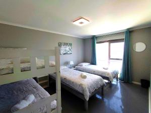 a bedroom with two bunk beds and a window at Clarke House in Stompneusbaai