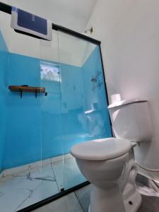 a bathroom with a toilet and a glass shower at Suíte de Marcio in Itacaré +4 photos