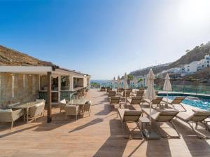 a row of chairs and umbrellas next to a pool at Sunset Suites by Bull Hotels in Puerto Rico de Gran Canaria