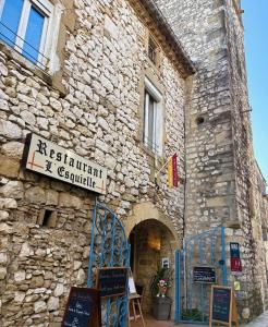 a stone building with a sign on the side of it at Logis Hotel Restaurant L'Esquielle in Saint-Géniès-de-Malgoirès