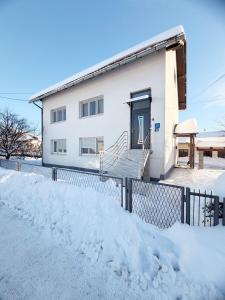 a house in the snow with a fence at Bajkoviti kutak in Ogulin