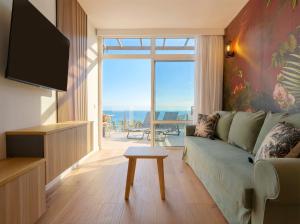 a living room with a couch and a view of the ocean at Sunset Suites by Bull Hotels in Puerto Rico de Gran Canaria