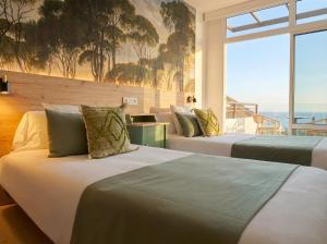 two beds in a room with a view of the ocean at Sunset Suites by Bull Hotels in Puerto Rico de Gran Canaria +49 photos