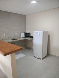a kitchen with a white refrigerator and a microwave at Valparaiso Hotel in Cruz das Almas